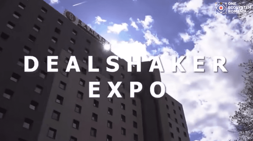 Edifici sota un cel brillant. En lletres blanques grans, diu "DealShaker Expo" i a la cantonada superior dreta té el logotip "One Ecosystem Romania". Aquest esdeveniment és un autèntic punt culminant dels esdeveniments a Romania.