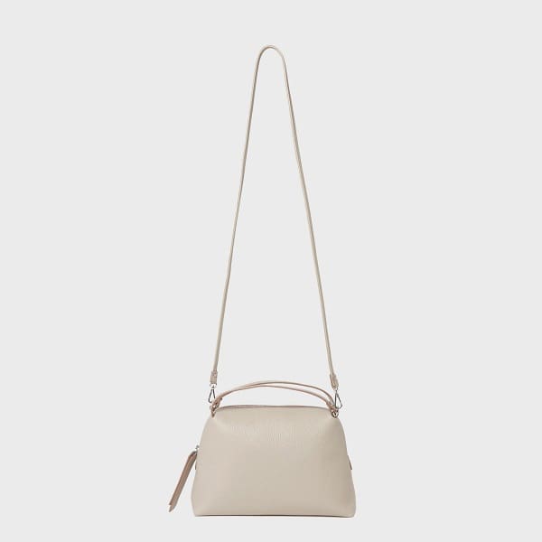 La bandolera GIANNI CHIARINI ALIFA fabricada en pell beix italiana presenta un disseny minimalista, corretges ajustables, nanses curtes i una part superior amb cremallera.